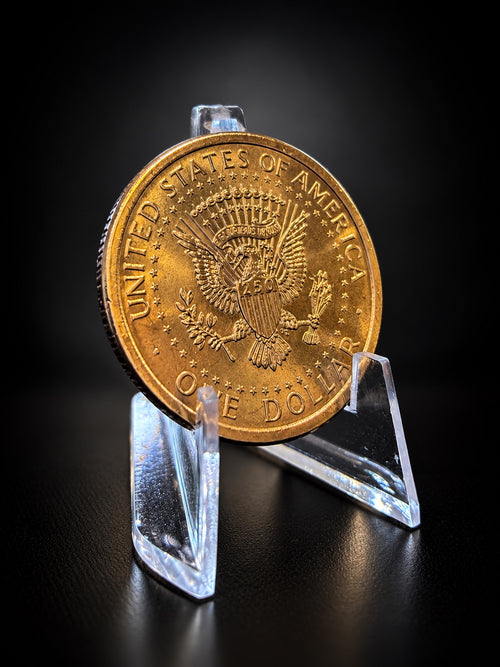 Semiquincentennial dollar eagle reverse on a clear stand against a black background